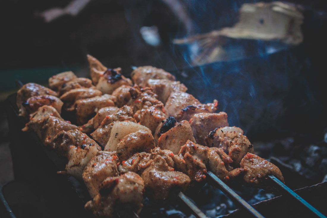Lamb skewers sizzling over glowing charcoal
